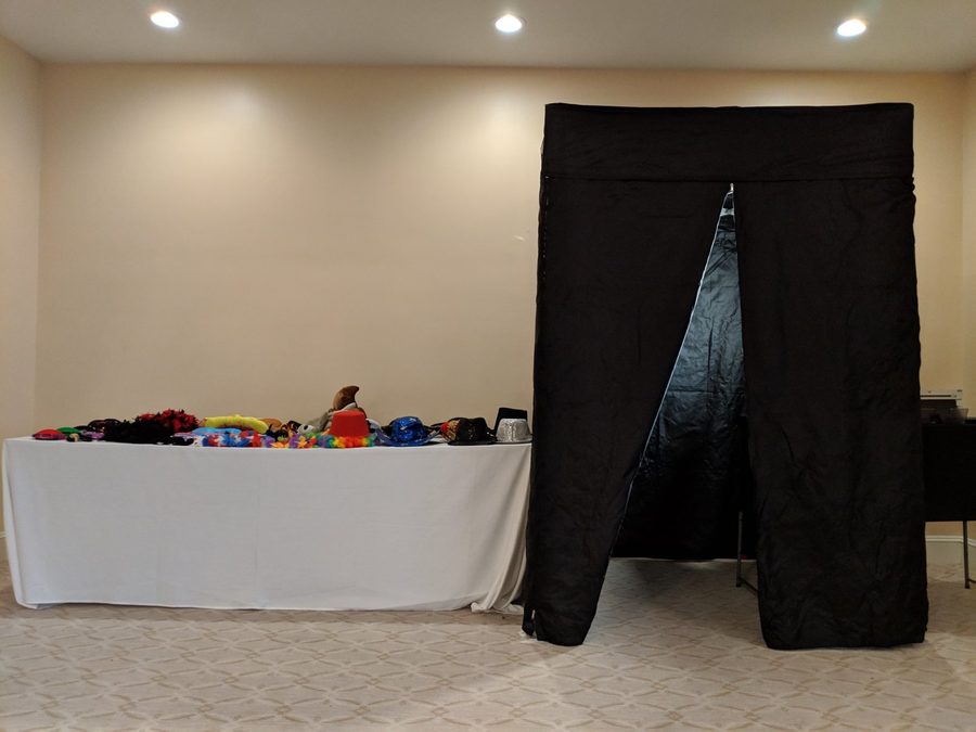 The Frame Us Photo booth set up at a venue, with the prop table alongside it.